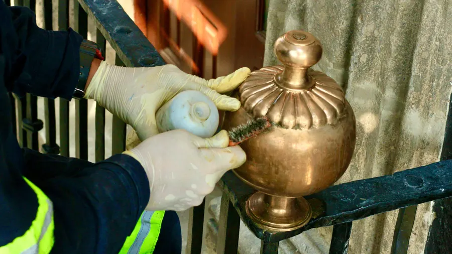 Limpieza de un remate metálico de bronce en una reja histórica