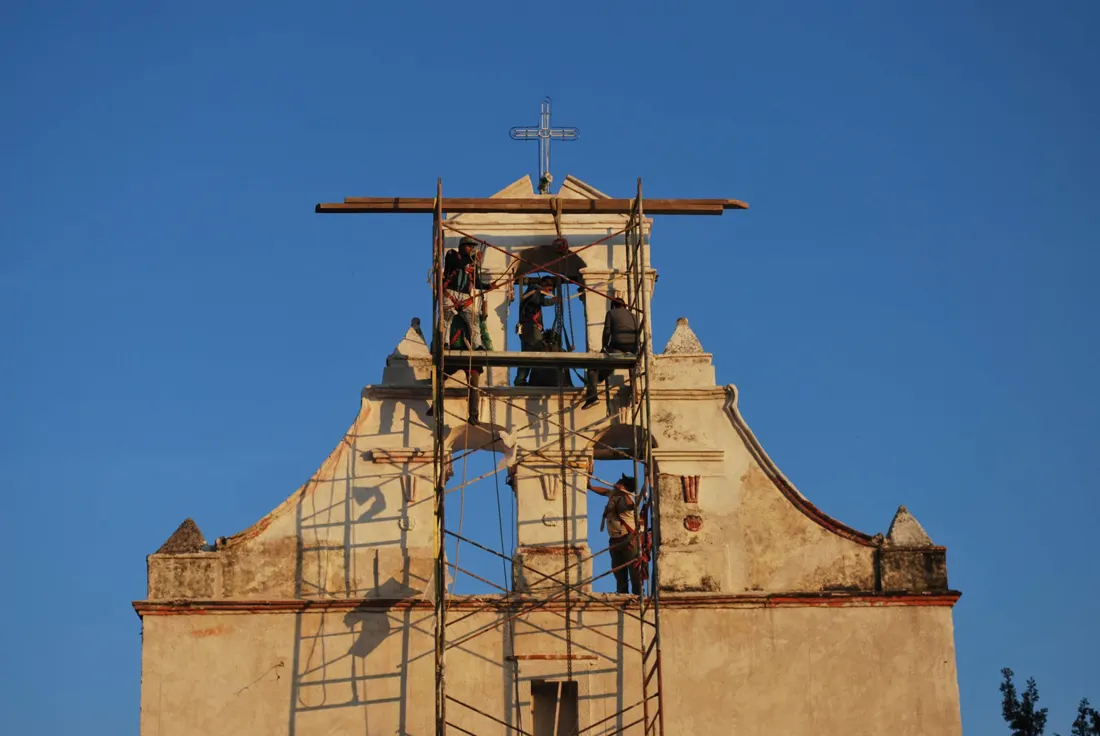 Fachada y campanario de un templo con andamios durante su restauración
