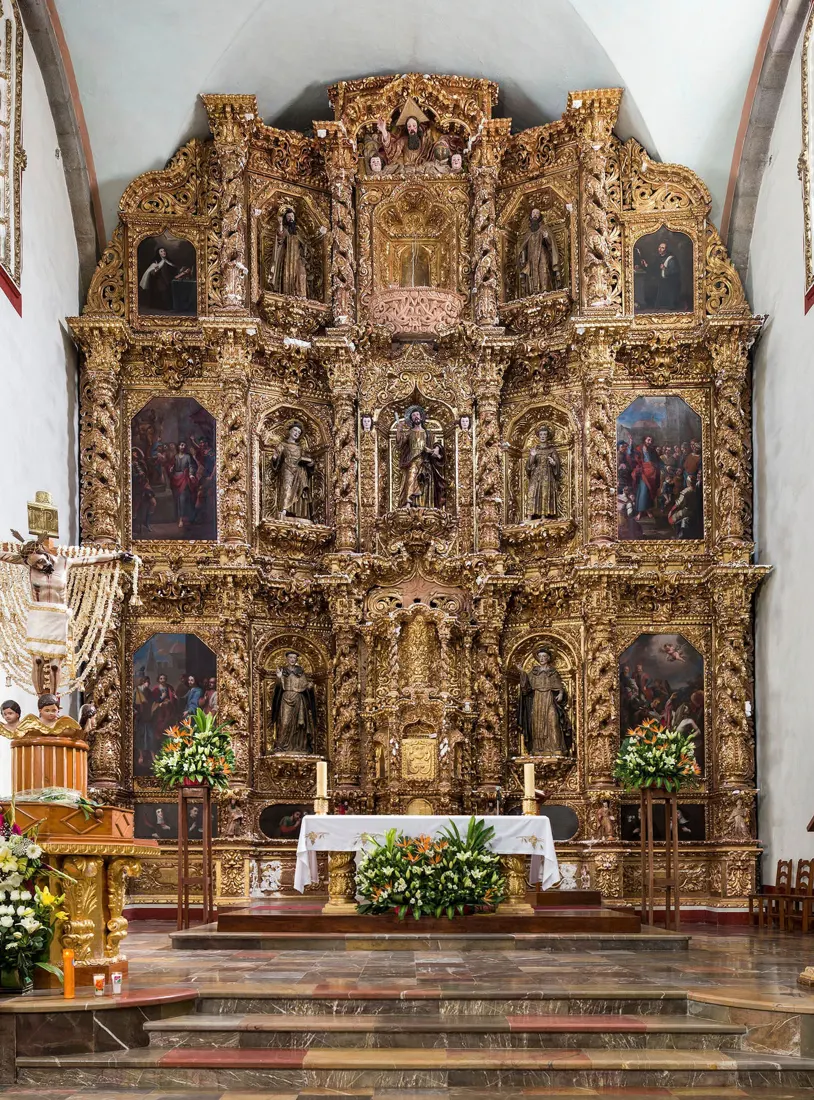 Retablo barroco dorado restaurado en el presbiterio de un templo