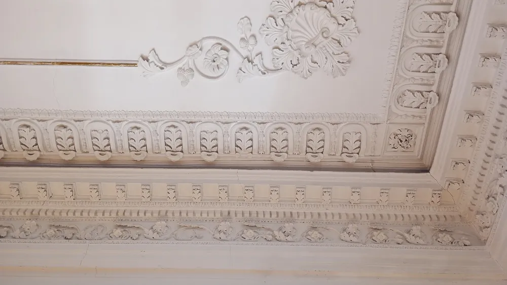 Yesería ornamental restaurada en plafón y cornisa de un edificio histórico